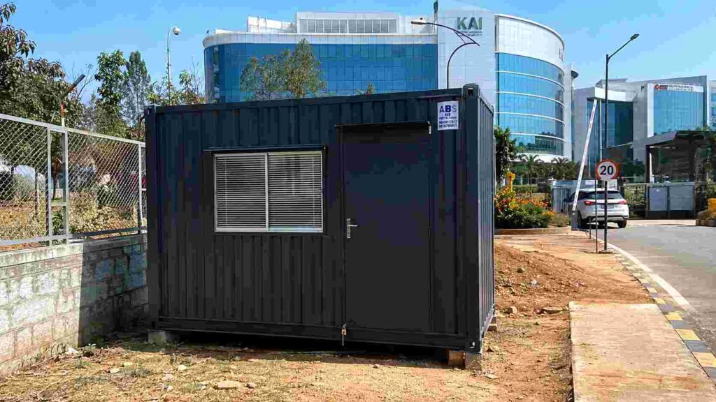 Anthracite Grey porta cabin installed on a Whitefield IT-campus perimeter site with a tech park building visible behind.