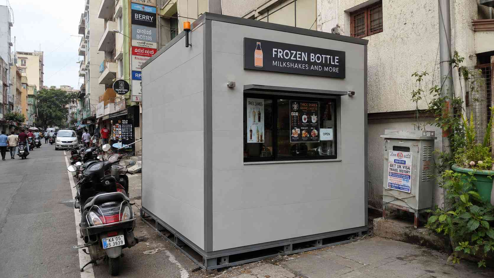 A pearl grey 8×8 ft porta cabin installed as a small retail kiosk on a Frazer Town-style commercial street in Bangalore.