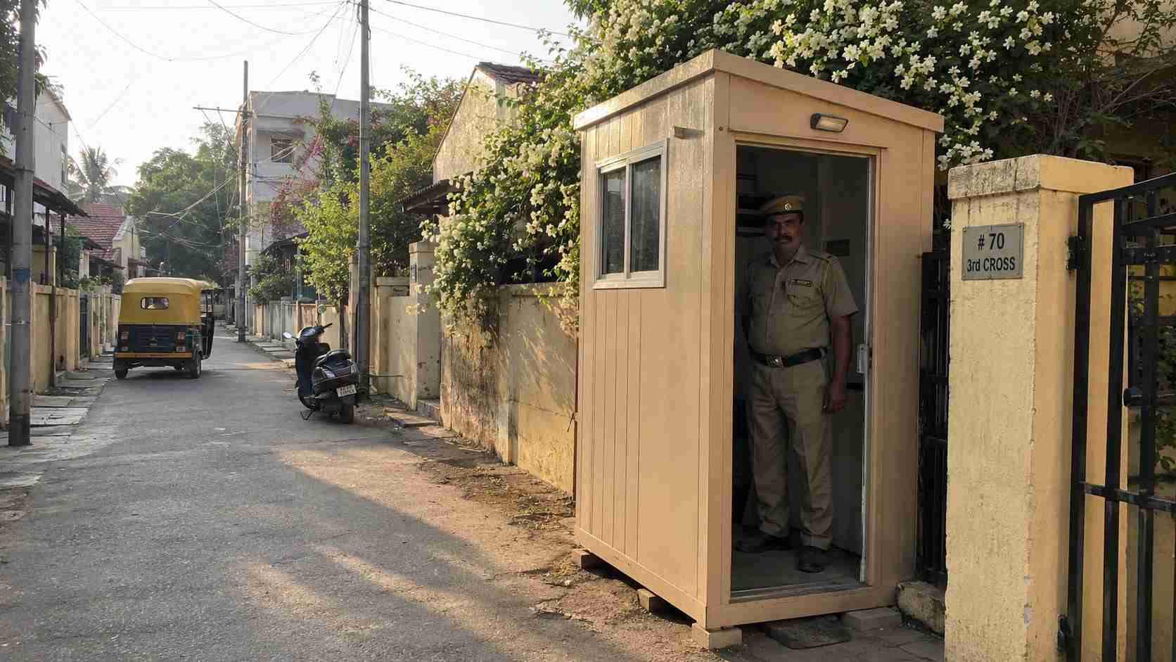 Sandstone beige 6 by 6 ft mini porta cabin used as a guard post on a narrow residential lane in Frazer Town Bangalore.