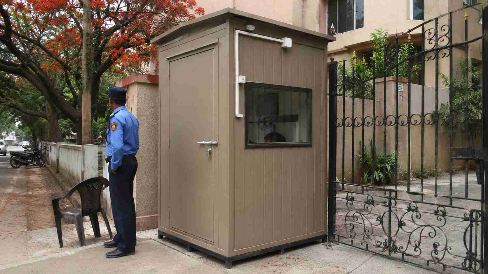 A warm taupe 6×6 ft porta cabin installed as a security gate cabin at a Bangalore residential society entrance.