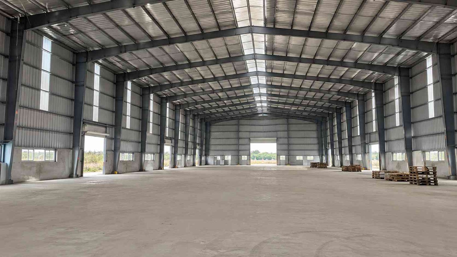 Clear-span interior of a steel-grey industrial shed with no internal columns and high eave height.