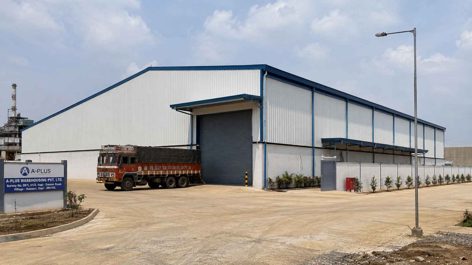 Pre-engineered steel warehouse with a Steel Blue roof and off-white cladding on an Indian industrial estate.