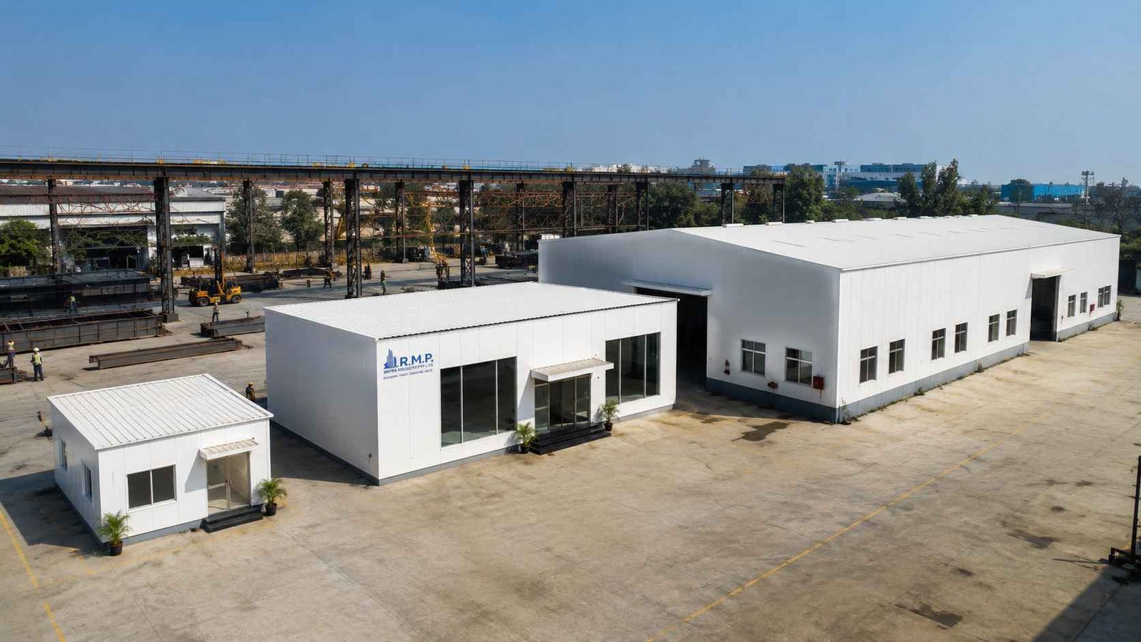 Three pure white prefab buildings of different sizes lined up showing SAMAN's range from compact office to industrial.