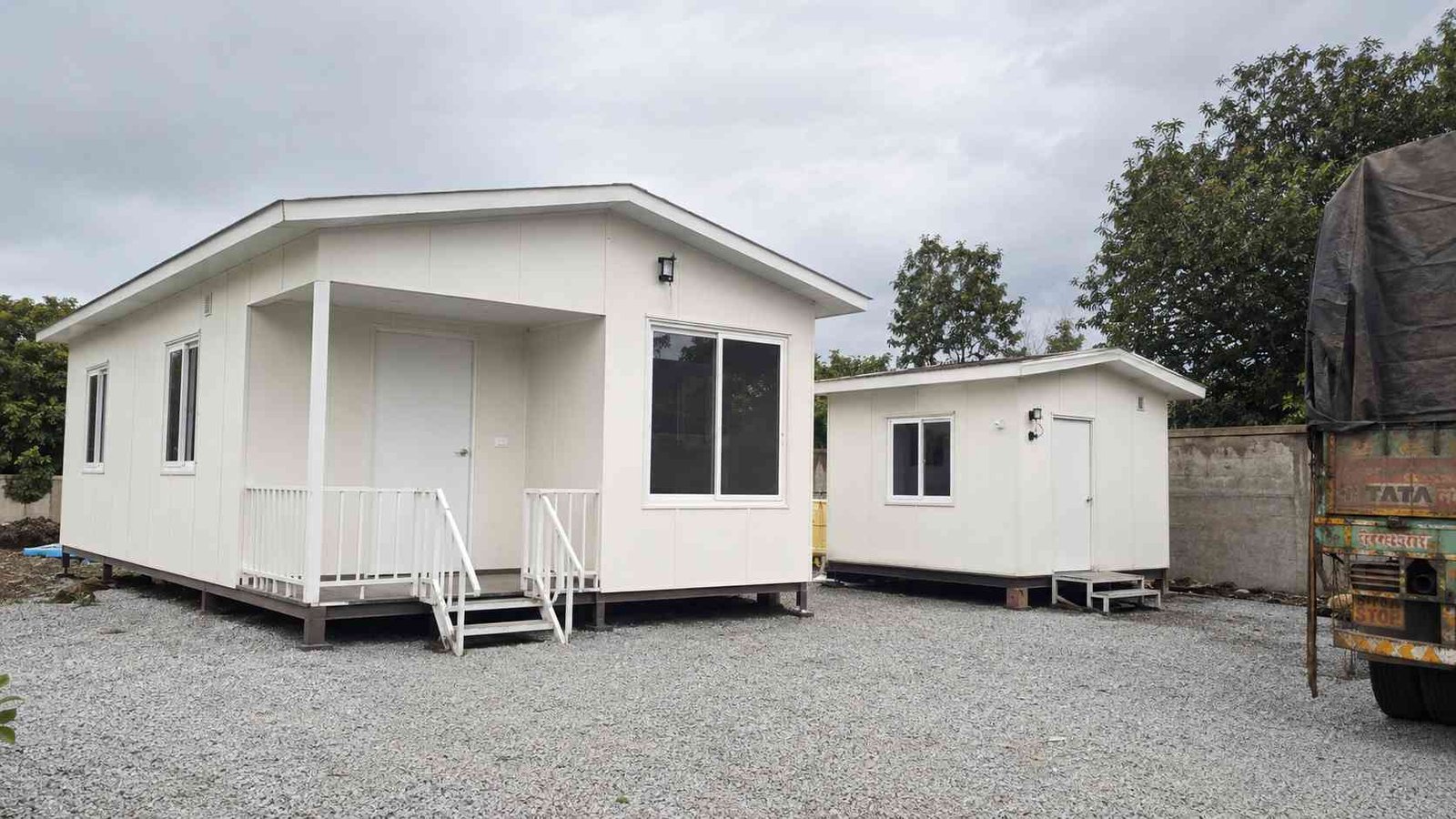 A pure white prefabricated home beside a prefab site office, showing SAMAN's range of factory-built units.