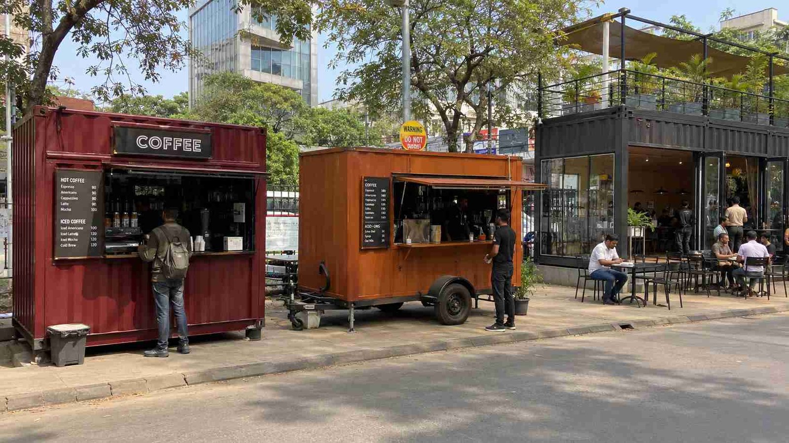 Three container cafe formats side by side — burgundy coffee kiosk, terracotta mobile cafe and a fixed cafe.