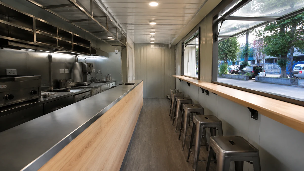 Clean interior of a new container cafe unit with counter, compact kitchen and seating ledge