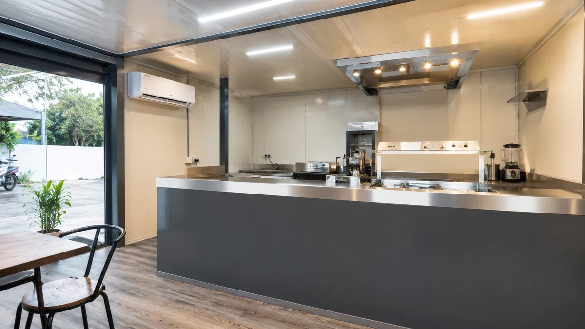 Inside a container cafe showing counter, kitchen and seating layout