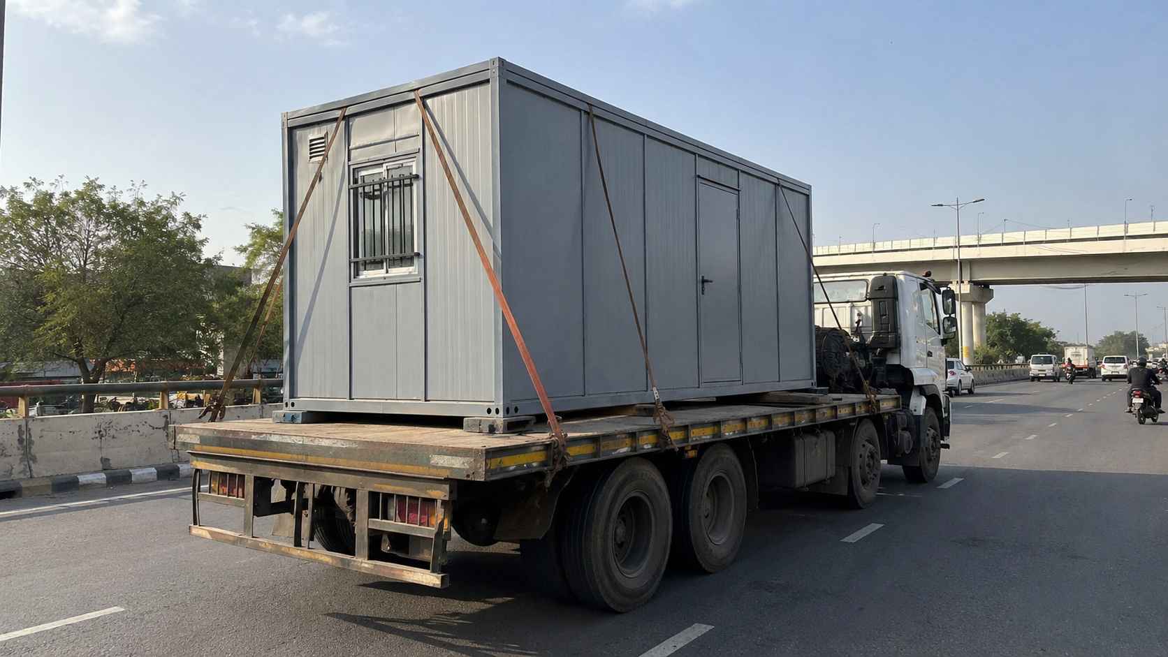 SAMAN porta cabin loaded on a flatbed truck for delivery from the Gopasandra factory to a Yelahanka site